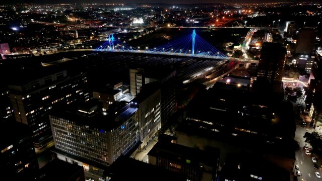 Nelson Mandela Bridge In Johannesburg Gauteng South Africa. Cars Driving Towards Downtown City On The Famous Bridge. Building Sky Downtown Cityscape. Night Exterior Panning Wide.