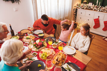 Multi-generation family having Christmas dinner together at home