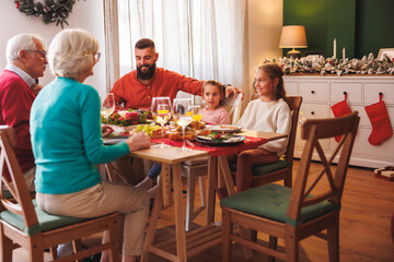 Multi-generation family having Christmas dinner together at home