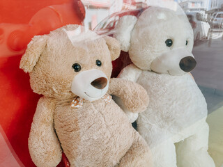 Two large teddy bears behind store window, perfect childhood symbol and toy shop display