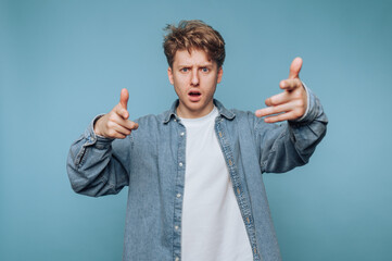 portrait of young man features excitement and energy while playfully pointing at the camera,...