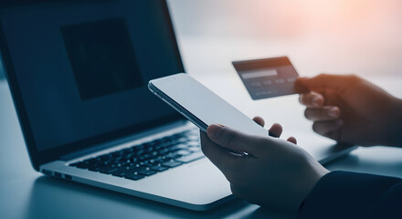 Hands Holding Smartphone and Credit Card Shopping Online with Laptop in Background