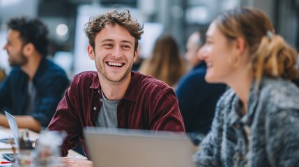 Fototapeta premium Two young adults laughing in a shared workspace