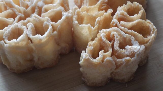 Detailed zoom in shot of a traditional Spanish fried sweet known as Flor Frita, sprinkled with sugar.