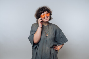 portrait of young surprised curly-haired woman engaged in a phone call on light background