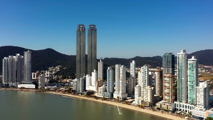 Naklejka premium Highrise Buildings In Balneario Camboriu Santa Catarina Brazil. Bird Eye View Of Famous Building In Vibrant District Of City. Shore Clouds Sky Beach Sea.