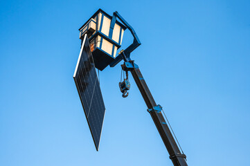 Hydraulic basket hanging piece of solar panel in the sky ready to install on high roof