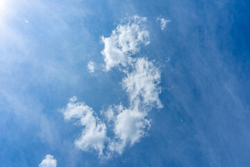 A single fluffy cloud drifts peacefully across the clear blue sky, adding softness to the vast open...