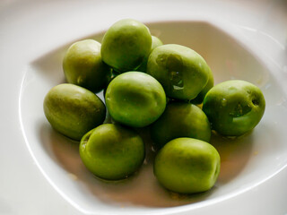White plate filled with large olives. Taken in Tremosine.
