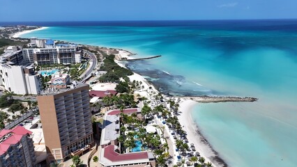 Naklejka premium Palm Beach In Noord Oranjestad Aruba. Capturing The Beauty Of A Tropical Beach From Above. Shore Clouds Sky Beach Sea. Shore Travel. Noord Oranjestad.