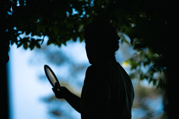 silhouette of a discgolf player