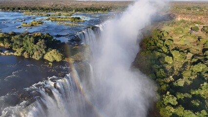Victoria Falls In Livingstone Northern Rhodesia Zambia. Rainbow Forming Over Waterfalls With River In Background. Recreation Forest Water Fall Beautiful. Recreation Tropical Landscape.
