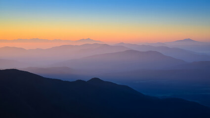 Fototapeta premium Sunrise and sunset over misty mountain landscape with clouds and forest viewSunrise and sunset over misty mountain landscape with clouds and forest view. AI generated