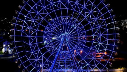 Ferris Wheel In Rio De Janeiro Brazil. Bird Eye View Of Stunning Ferris Wheel In A Amusement Park. Building Sky Downtown Cityscape. Night Exterior Panning Wide. Rio de Janeiro Brazil.