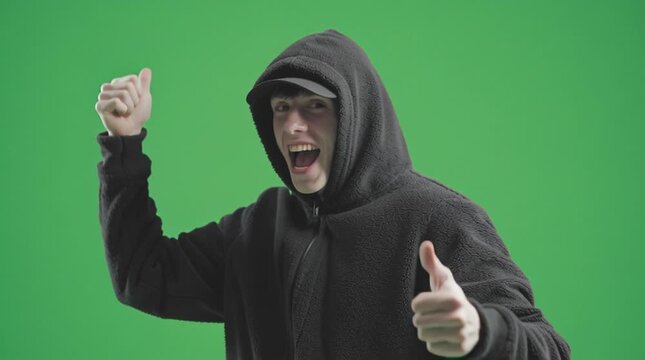  young man giving thumbs up and smille winning reaction wearing hood 