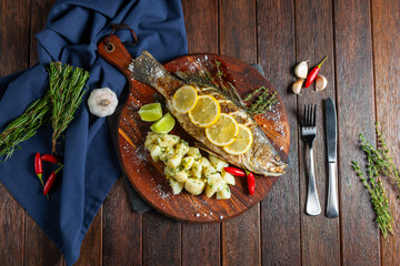 Herb-Lemon Fish on Wooden Board