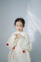 Young girl in cozy white sweater with playful style.