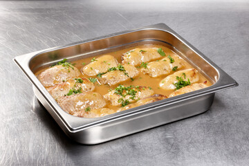 Tender pieces of chicken are simmered in a rich sauce and garnished with fresh herbs, displayed on...