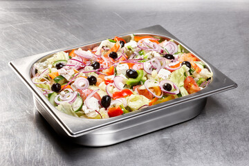 A vibrant garden salad featuring a mix of crisp lettuce, fresh tomatoes, sliced onions, and olives...