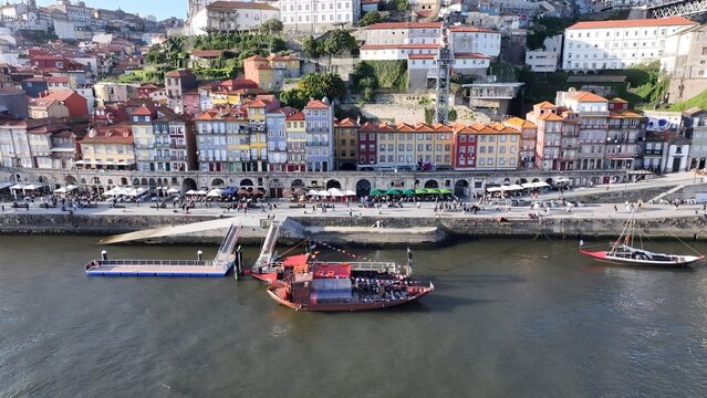 Ribeira Pier In Porto Portugal. Aerial View Of A River Surrounded By Lush Green Tropical Rainforest. Town Sky Backgrounds Urban. Town Outdoor Panning Wide. Porto Portugal. - Powered by Adobe