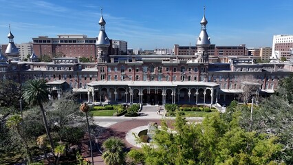 Fototapeta premium Henry Plant Museum In Tampa Florida United States. Drone Captures A Garden With Sidewalks Surrounded By Lush Trees. Town Clouds Sky Backgrounds Urban. Backgrounds Downtown Panoramic City.