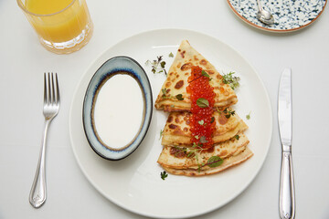pancakes with caviar in a restaurant on a table and white tablecloth