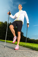 Germany, Bavaria, Munich, young, athletic man doing Nordic walking