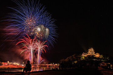 日本の愛媛県にある大洲城と夏の夜空を彩る大迫力の花火大会の風景

