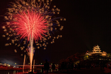 日本の愛媛県にある大洲城と夏の夜空を彩る大迫力の花火大会の風景

