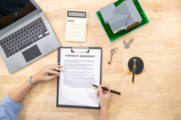 Real estate agents are checking customer information and preparing contract documents selling real estate ready for signing the contract to complete the real estate transaction legally.