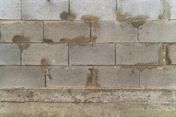Gray concrete block wall with visible texture and imperfections, showcasing construction materials and techniques, ideal for backgrounds or architectural design projects with copy space