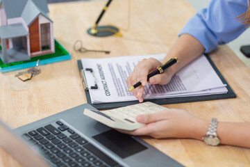 Real estate agents are checking customer information and preparing contract documents selling real estate ready for signing the contract to complete the real estate transaction legally.