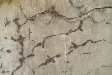 Textured concrete wall with visible cracks and imperfections, showcasing a weathered surface that adds character and depth, ideal for backgrounds in design and architectural projects