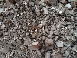 A pile of broken red bricks and fragments of concrete. Pile of debris of a torn down building