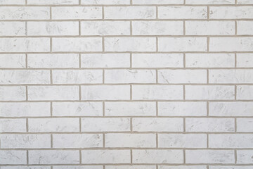 Textured white brick wall with subtle variations in color and pattern, creating a clean and modern aesthetic, ideal for backgrounds and design projects with copy space