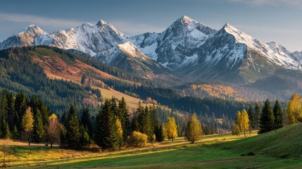 Obraz premium Majestic mountain range with snow-capped peaks, forested slopes, and autumn hues