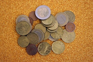 Big amount of euro coins on golden glitter background