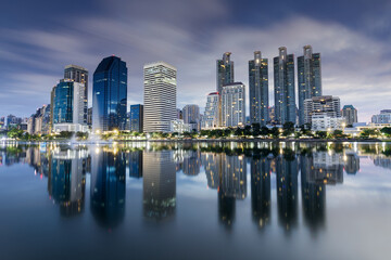 Peaceful sunrise view at Benjakitty Park in Bangkok, Thailand, with calm lake waters reflecting...