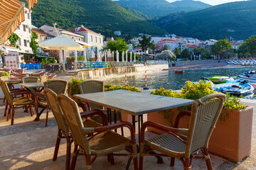 cozy outdoor cafe or restaurant located on embankment with panoramic view of Petrovac city,...