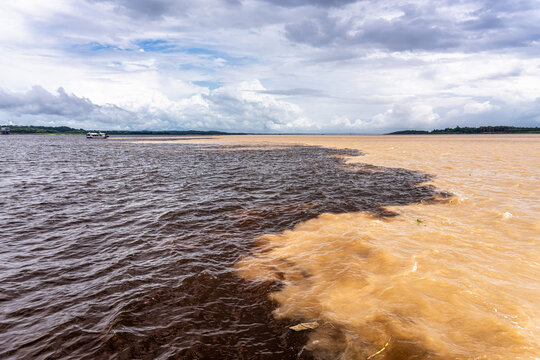 Meeting of the waters of the Negro and Solimoes rivers in the city of Manaus in Amazonia, Brazil - Powered by Adobe