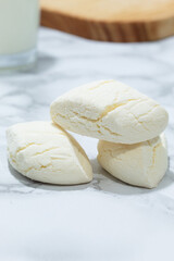 Handmade Colombian white cookies served on marble with a neutral background and a glass of milk, evoking home-cooked meals with traditional recipes and local baked goods
