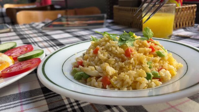 pecel is a stew of long beans, sprouts and mustard greens sprinkled with crushed peanut sauce and peanut brittle as a complement, a close up of warm pecel rice served on a ceramic plate on the table