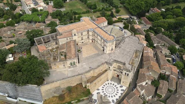 Aerial drone view of Grignan Castle surrounded by lush greenery and historic village in Provence, France &ndash; medieval fortress with scenic landscape and vibrant natural surroundings