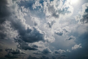 Dramatic cloudy sky with dark storm clouds and sunlight breaking through, creating a contrasting...