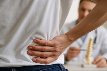 A patient with back pain consults a doctor in a clinic, discussing spine health and treatment options for injury or disease, focusing on healthcare and wellness