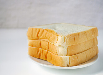 White sliced bread stacked on the white wooden table