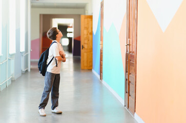 Curious student looking up in colorful school hallway