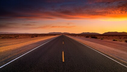 Fototapeta premium endless desert road under a warm orange sky at dusk