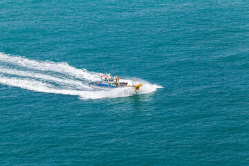 Large Fishing Boat Navigating Through Blue Ocean Waters at High Speed