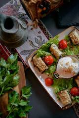 A Delicious Plate of Freshly Prepared Appetizers with Creamy Dip, Served with Lettuce, Cherry Tomatoes, and Garnished with Fresh Herbs on a Rustic Table Setting